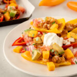 Plate with mini pepper nachos and sour cream