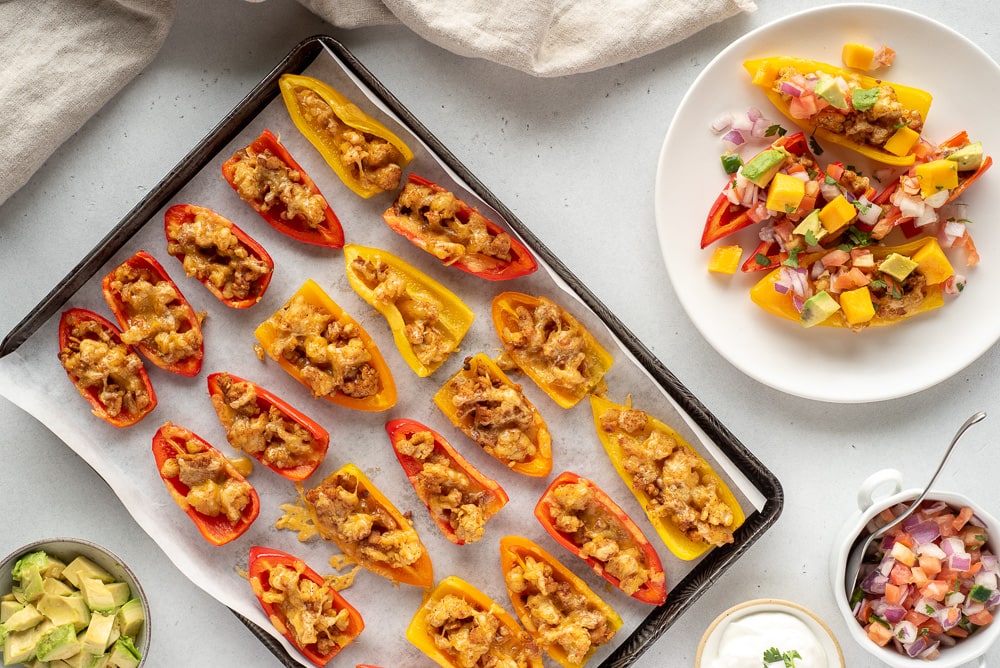 Top down view of a pan of mini pepper nachos next to one serving on a plate