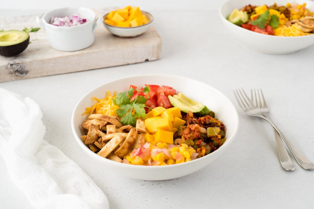 Bowl of taco ingredients next to cutting board