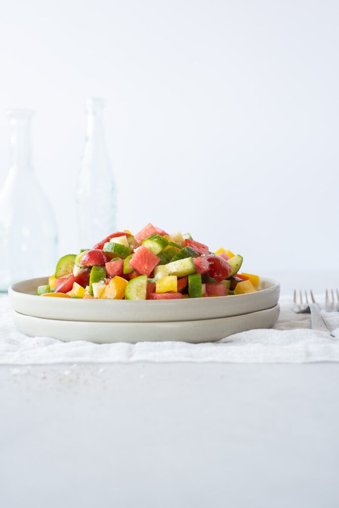 Side view of a plate full of colorful fruit and veggies