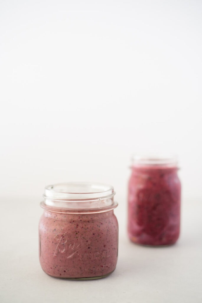 Two mason jars filled with pink smoothies
