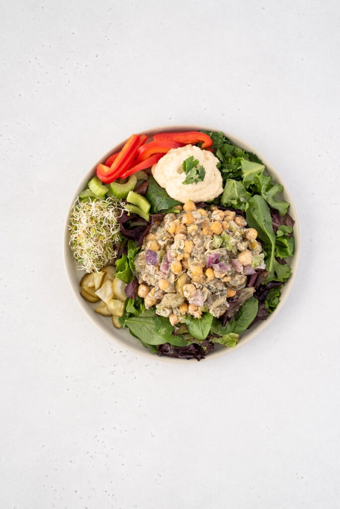 Top down view of chickpea tuna salad on a plate with veggies