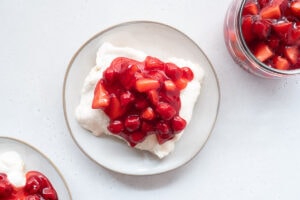 Plate with meringue dessert topped with cherries