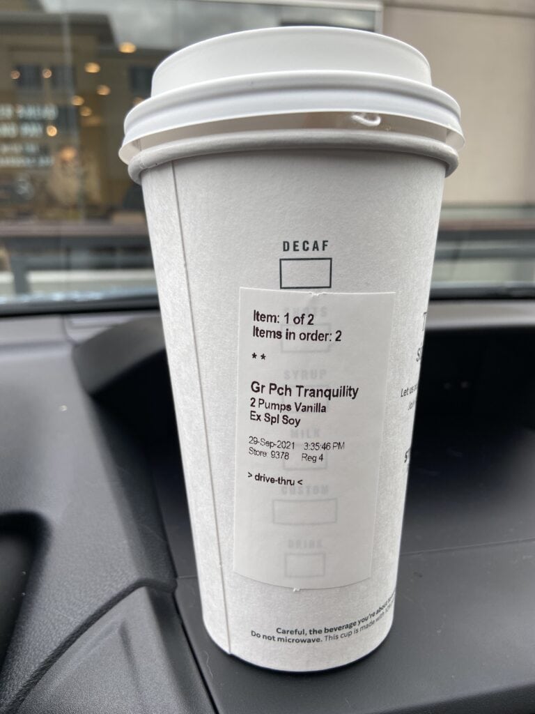 Hot Starbucks cup of tea sitting on a car dashboard