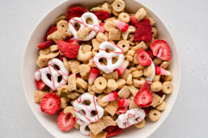 Close up on white bowl full of Valentine snack mix