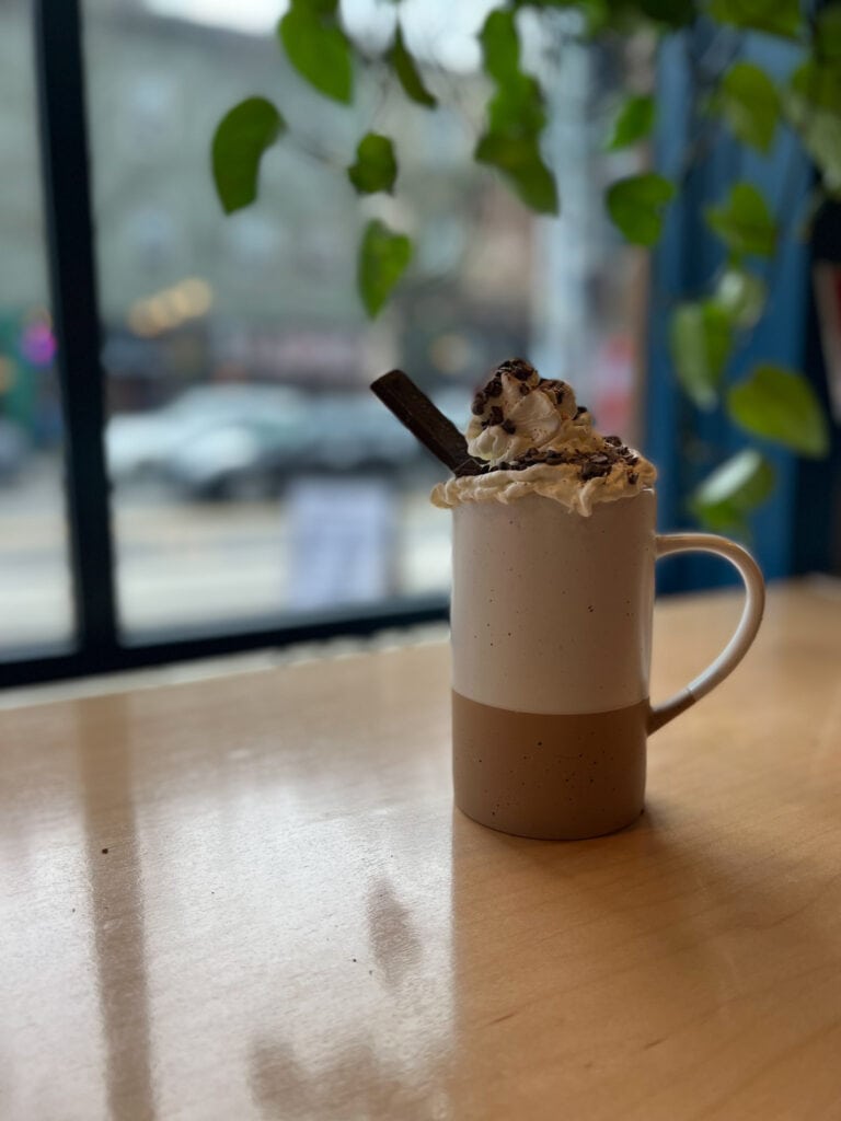 Mug on a table topped with whipped cream