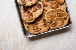 Several naan breads on a sheet pan