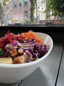 White oval bowl filled with vegetables and tofu