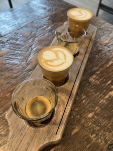 Four small glass cups of espresso on a wooden tray