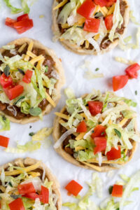Top down view of 4 sopes with mole and toppings