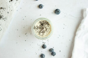 Top down view of a jar of chia pudding surrounded by blueberries