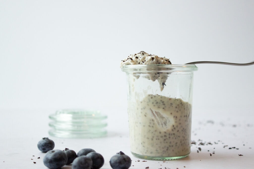 Jar of chia pudding with a spoonful resting on top