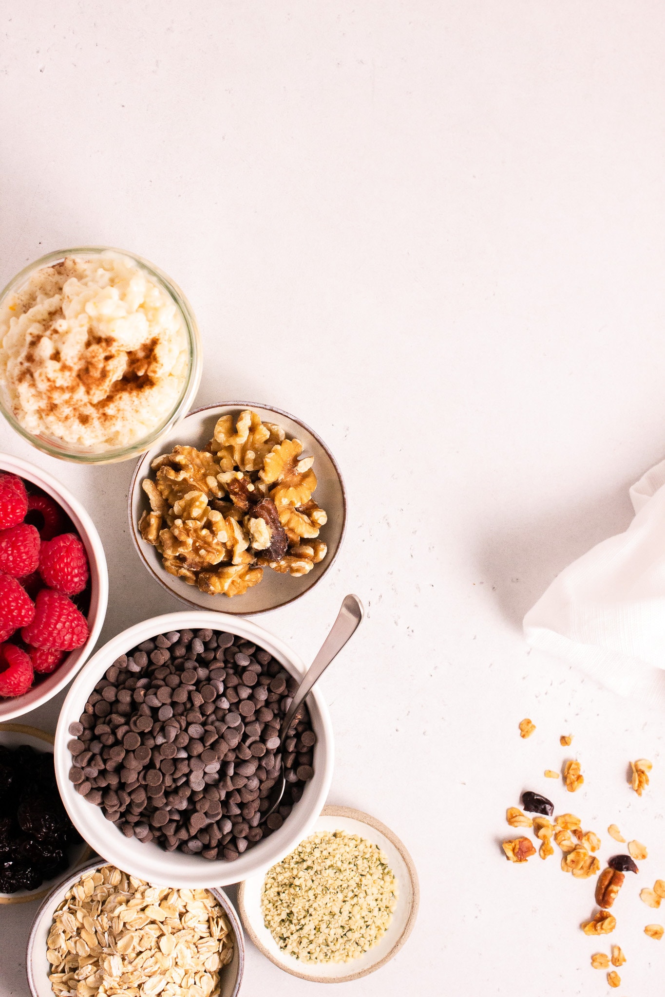 Top down view of bowls full of berries, nuts and chocolate chips