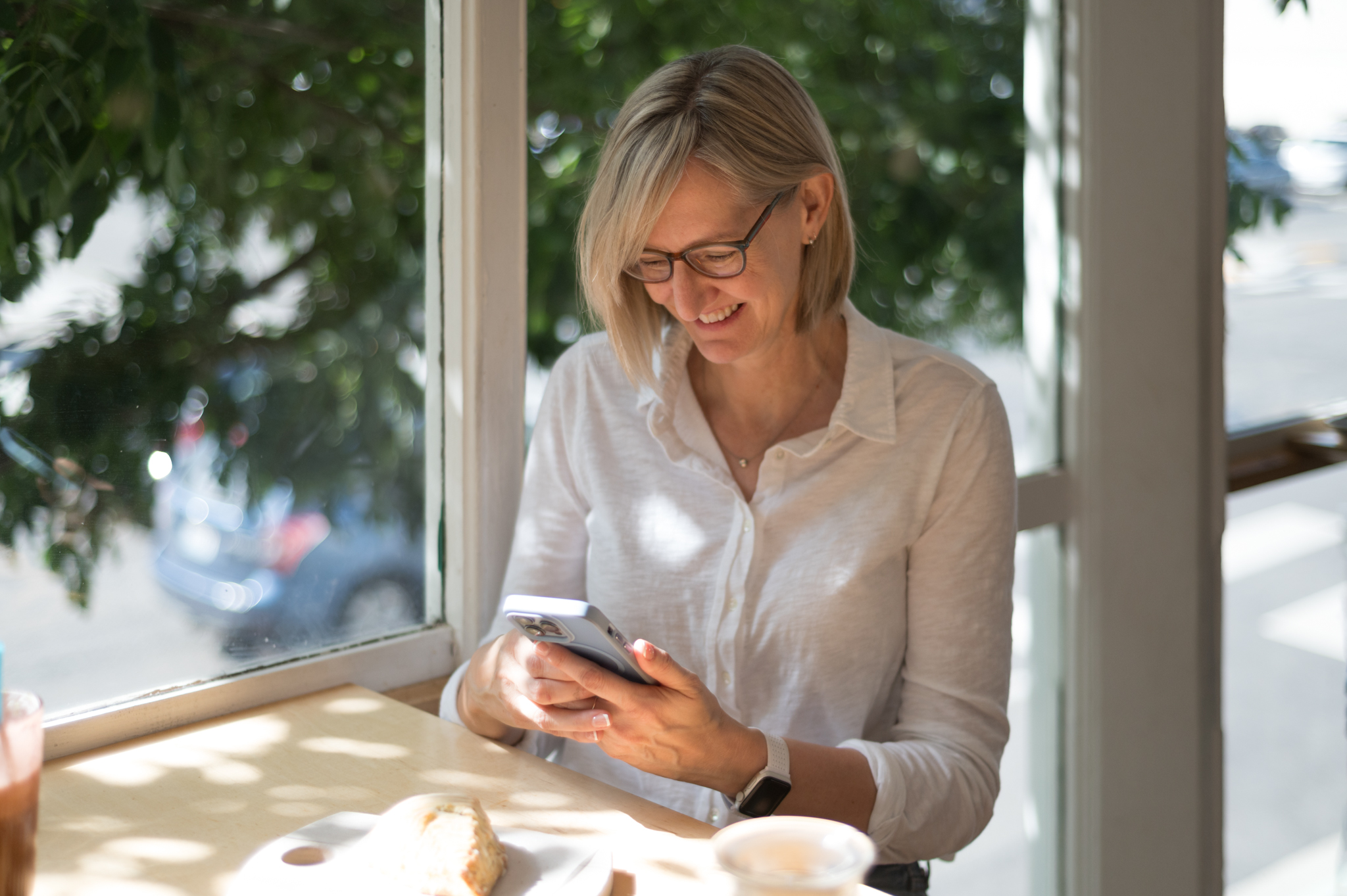 Woman in a coffee shop taking pictures of her breakfast
