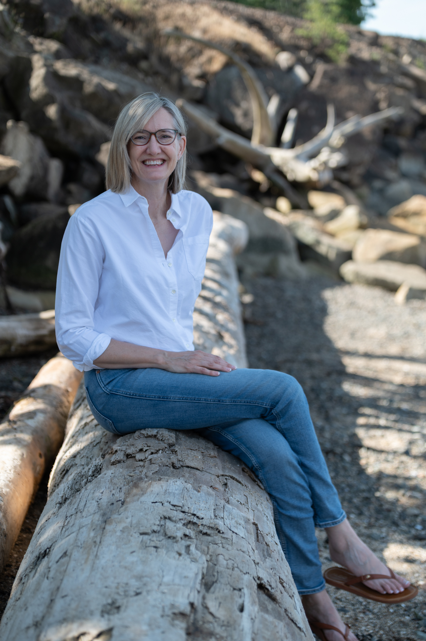 Woman siting on a log on the beach