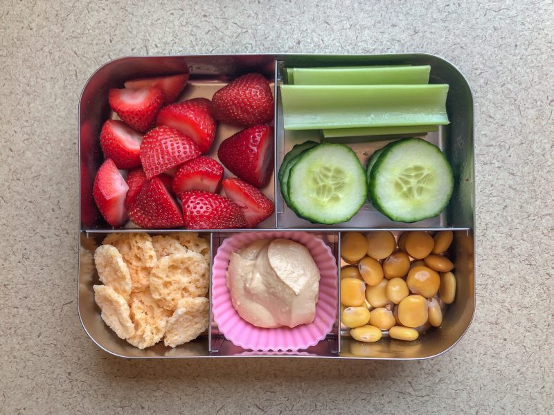 Bento box filled with berries, celery and beans