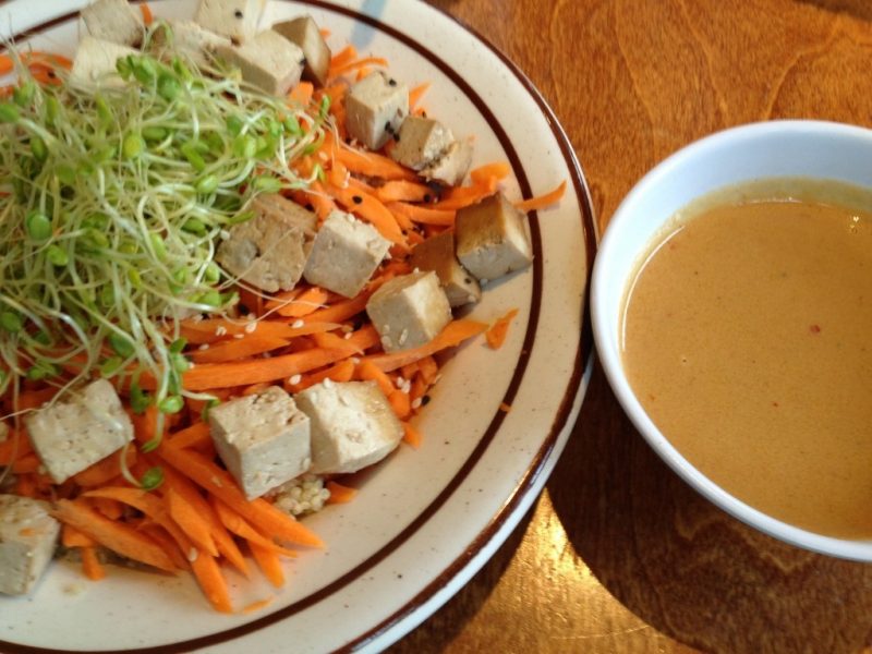 Bowl of tofu and veggies next to a bowl of sauce