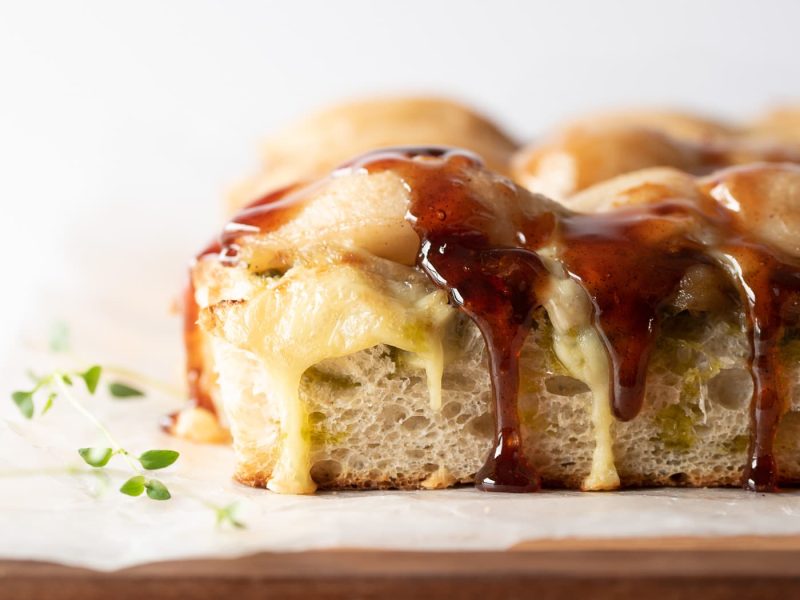 Close up of a slice of focaccia with pears and cheese on top