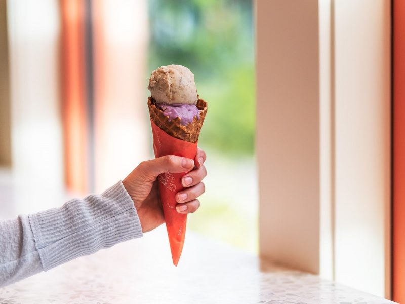 Outstretched arm holding an ice cream cone