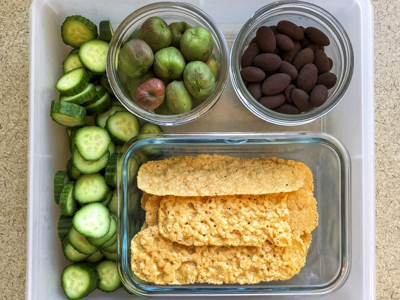 Tupperware filled with small containers of fruit and cheese