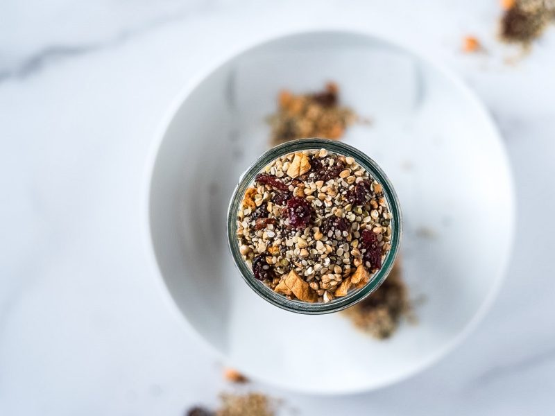 Top down view of a jar of seeds and dried fruit cereal