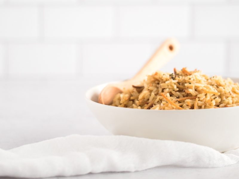 White bowl filled with rice and a spoon