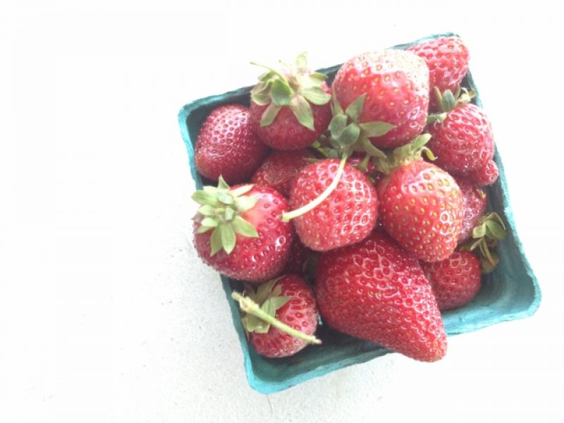 Overhead shot of a pint of strawberries in cardboard basket