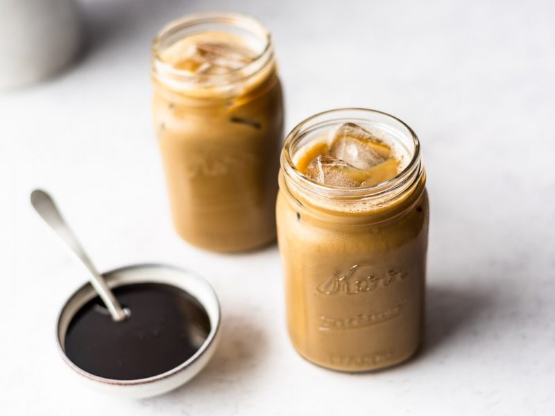 Two jars full of molasses milk next to a bowl of molasses