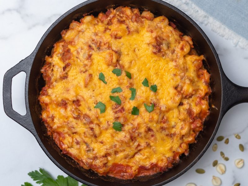 cast iron skillet filled with posole and cheese