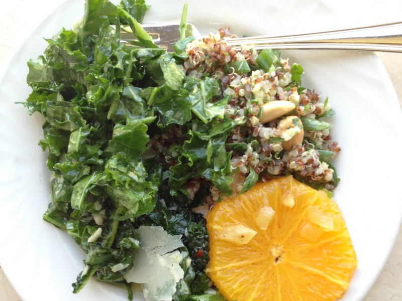Plate with kale salad and an orange slice