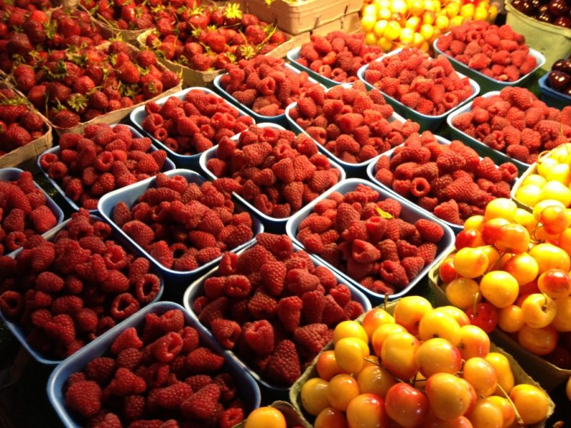 Baskets of cherries and raspberries at a produce stand